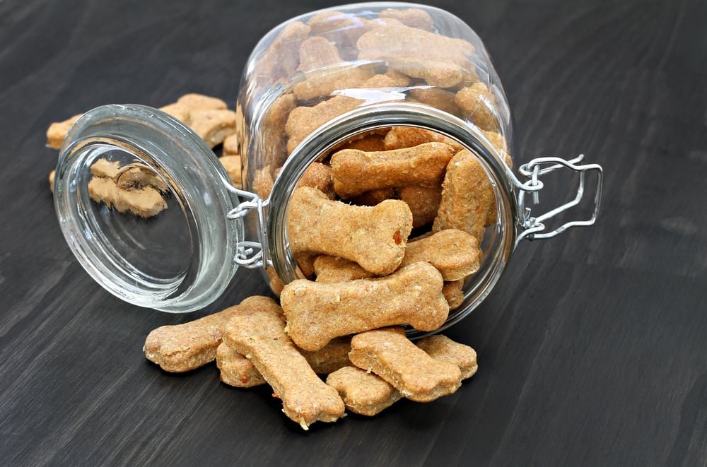Dog treats falling from a glass jar.