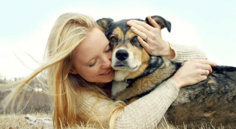 A girl hugging a dog.