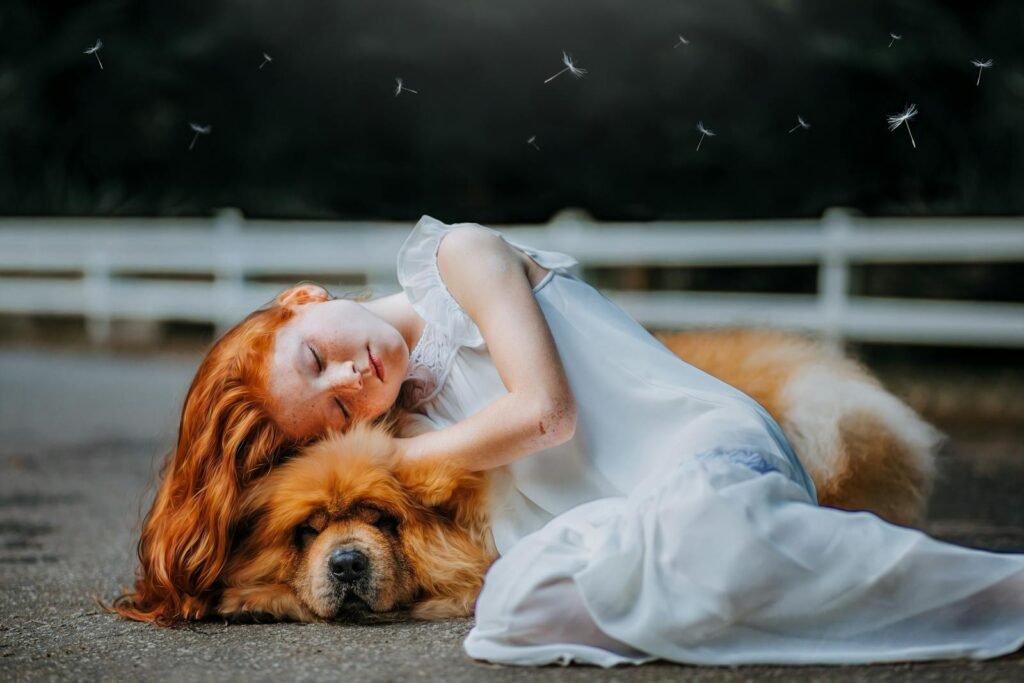 A serene scene of a red-haired girl sleeping on a fluffy dog outdoors.